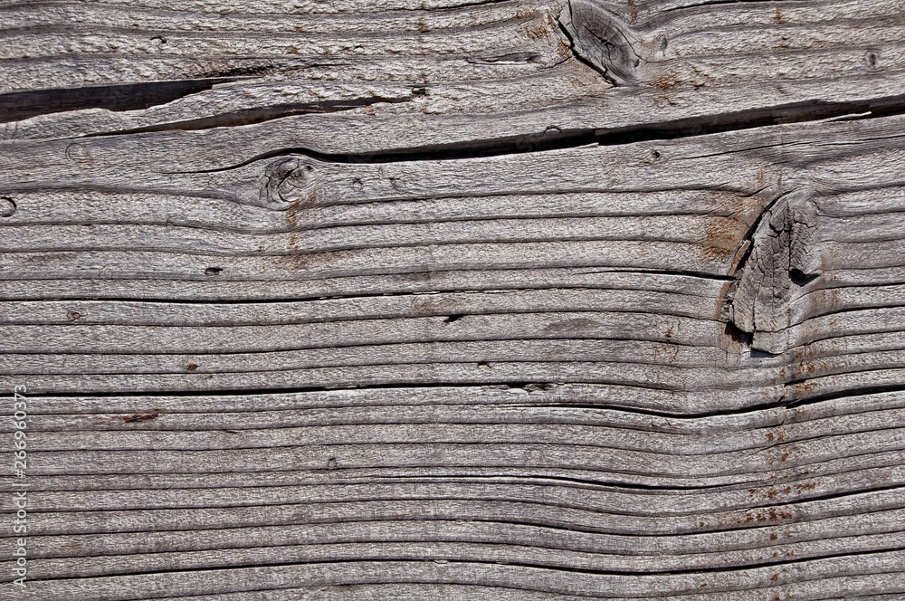 Texture photo of grey, worn, shabby, old and cracked wood which was exposed to weather and sun for years and which shows knots and growth rings. Ideal as a background Texture photo of grey, worn, shabby, old and cracked wood which was exposed to weather and sun for years and which shows knots and growth rings. Ideal as a background