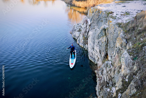 Swimming on the board on the water in the open air.