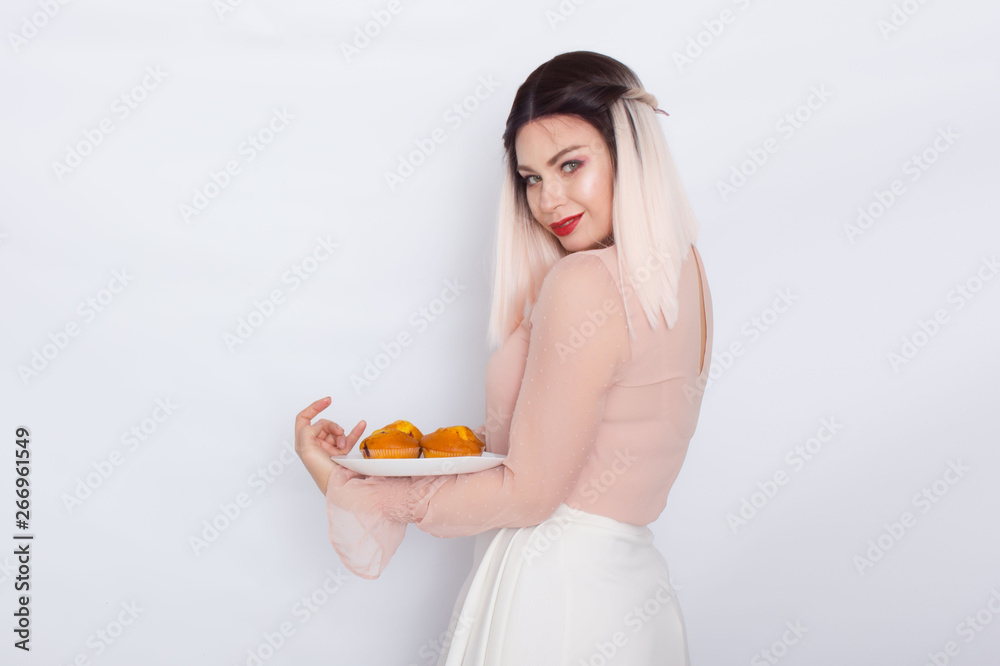 Blonde woman holding cakes on white plate Blonde woman holding cakes on white plate
