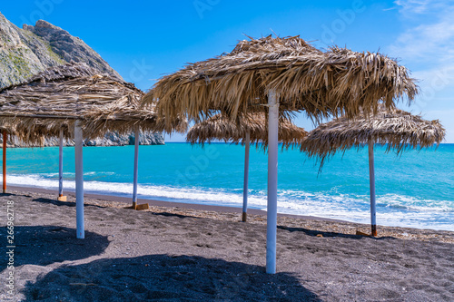 Umbrellas on the black sand beach in Perissa  Santorini  Greece