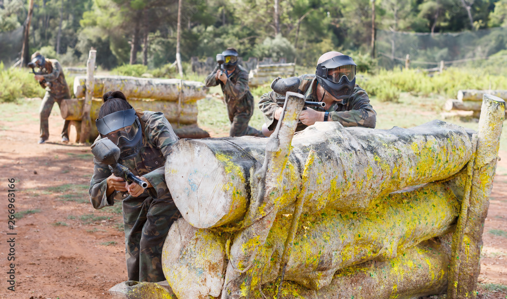 Fototapeta premium Paintball players aiming and shooting with guns