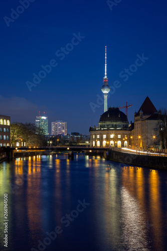 Cityscape of Berlin. Old and modern buildings and their reflections on the Spree River in Germany  at dusk. Fernsehturm TV Tower is in the background.