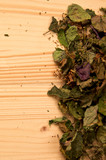 A large pile of dried Patchouli, Pogostemon cablin, leaves and flowers used for aromatherapy and incense on wood with copy space. Member of the mint deadnettle family.