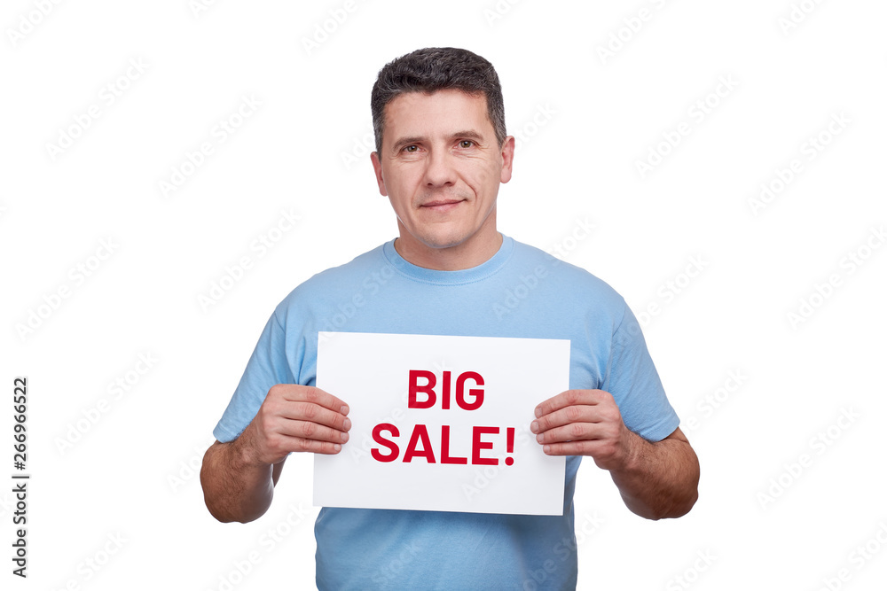 Adult man holds paper sheet with text big sale in two hands Adult man holds paper sheet with text big sale in two hands