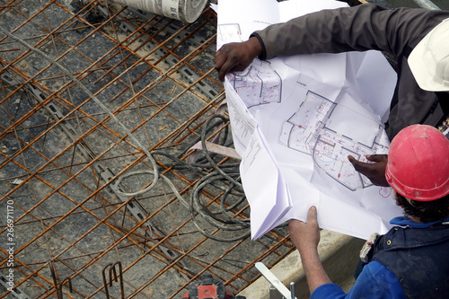 Un maître d'œuvre et un chef de chantier examinant un plan de construction