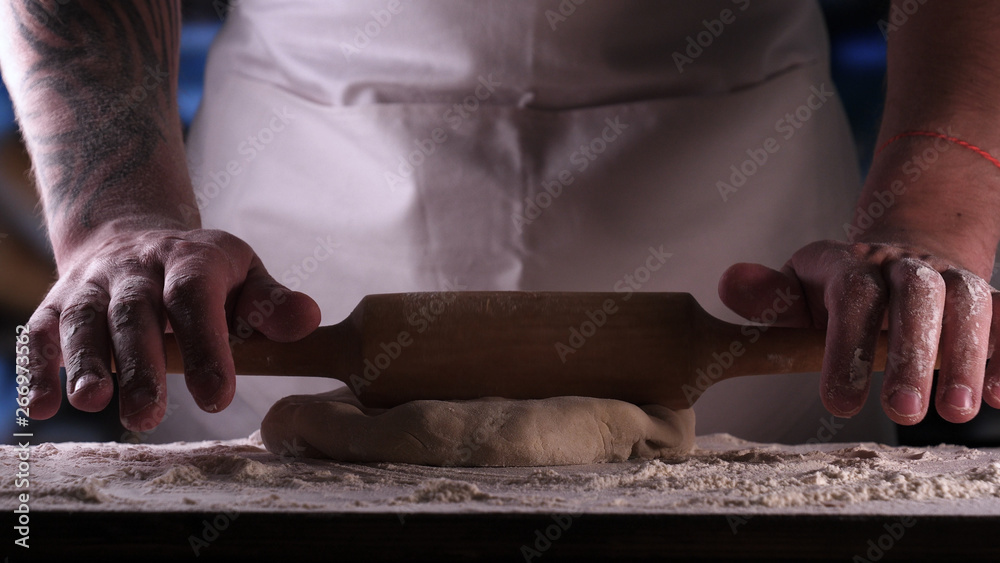 In the bakery, the hands of the baker are seen very closely as he prepares various flour products in an apron, after which he lays on the shelf. Concept of: Fresh Bread, Pizza, Bakery, Slow Motion. In the bakery, the hands of the baker are seen very closely as he prepares various flour products in an apron, after which he lays on the shelf. Concept of: Fresh Bread, Pizza, Bakery, Slow Motion.