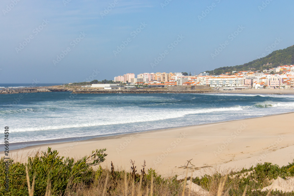 Wide empty beach with beautiful waves and white town on background. Vila Praia de Ancora, Portugal, landmark. Panoramic Atlantic Ocean coast with calm beach. White sand shore. Europe travel concept.
