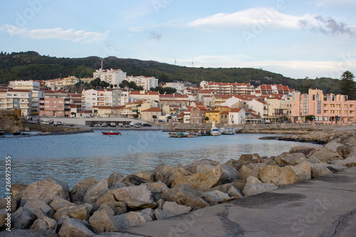 Vila Praia de Ancora, Portugal - 15/10/2018: Empty pier with stones and town in the evening. Calm coastal town landmark. Europe travel concept. Bay village and port background. 