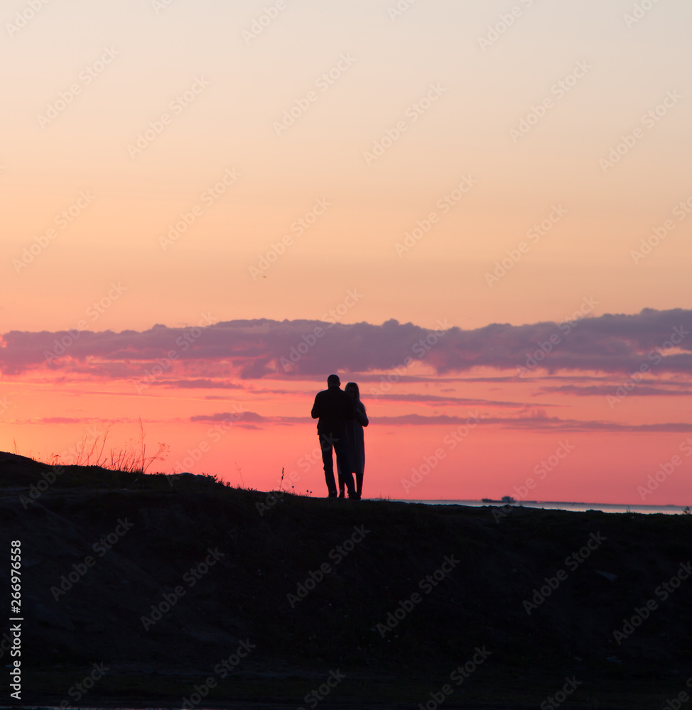 couple walking on beach at sunset