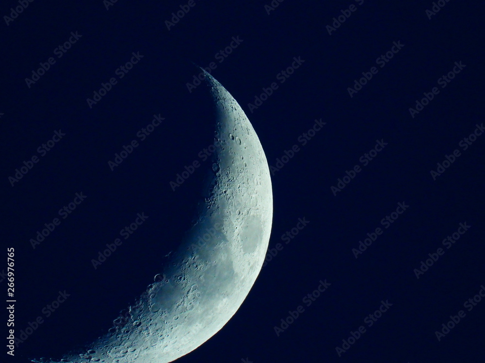 a rising quarter moon in the dark blue evening sky a rising quarter moon in the dark blue evening sky