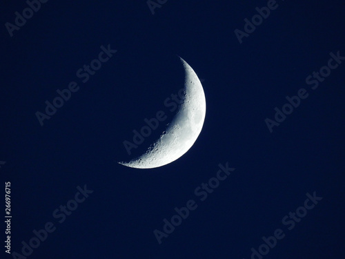 a rising quarter moon in the dark blue evening sky