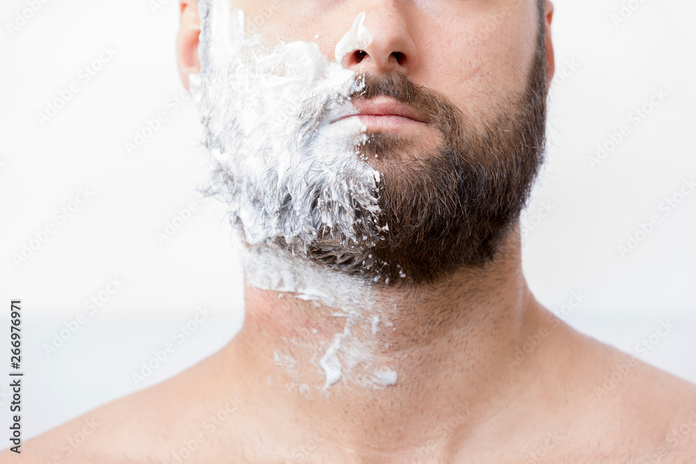 Man with half face in shaving cream Man with half face in shaving cream