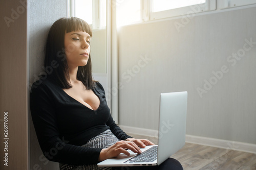 Εκτύπωση καμβά lateral view of a hot brunete in office outfit sitting on the floor and working