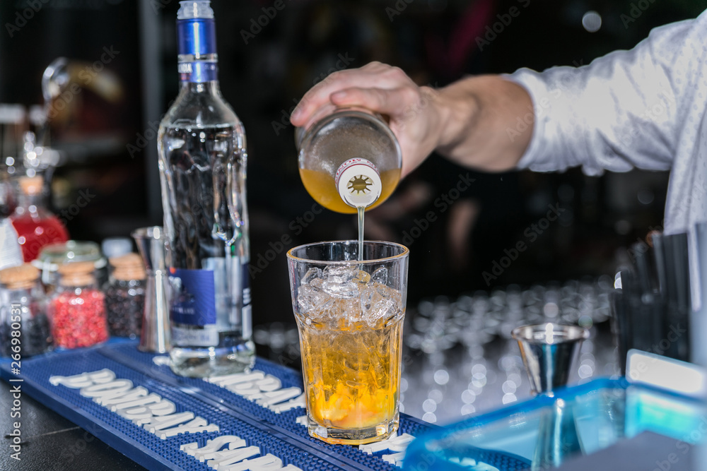 Closeup of barman hand putting on a glass to prepare cocktail. Closeup of barman hand putting on a glass to prepare cocktail.