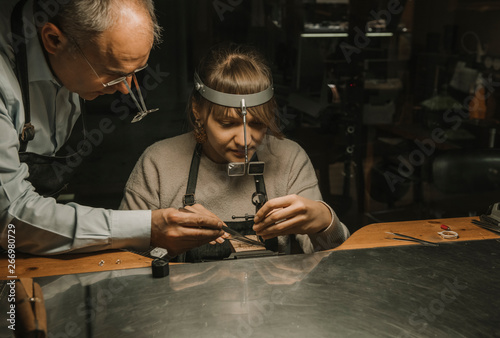 Artisan and his coworker making jewelry in his workshop photo