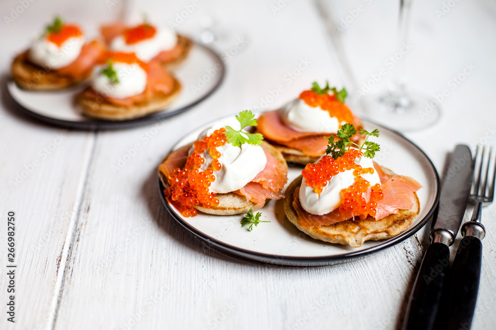 Russian style blini with salmon, sour cream and trout roe Russian style blini with salmon, sour cream and trout roe