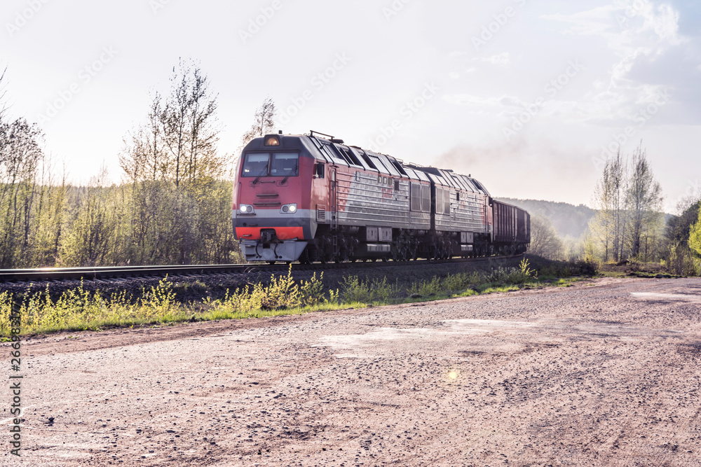 Freight train hauled by the diesel locomotives passing the forest Freight train hauled by the diesel locomotives passing the forest