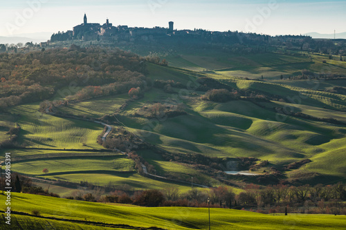 Picturesque landscape of green highlands with town in valley, Tuscany, Italy