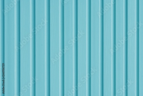 Element of the facade. Part of the facade decoration close-up. Facing material of buildings. Metal sheet roof. Vertical sheet. Blue color.