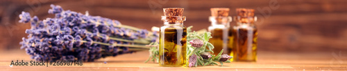 essential lavender oil in a glass bottle on a background of fresh flowers photo