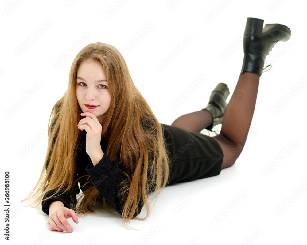 Teen girl lies in the studio on a white background. Teen girl lies in the studio on a white background.