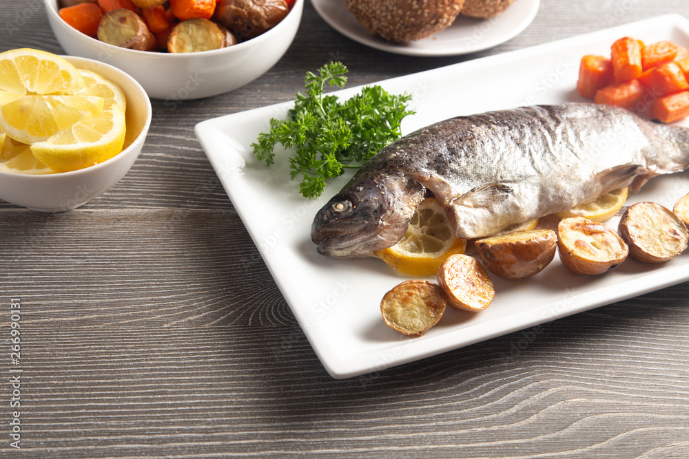 Whole Baked Rainbow Trout on a Table Set for Dinner Whole Baked Rainbow Trout on a Table Set for Dinner