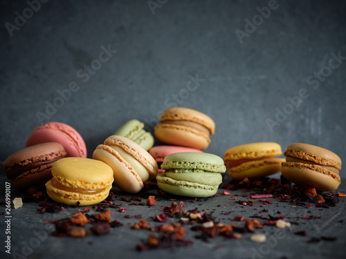 bright fresh tasty macaron biscuits on grey board and dry fruits photo