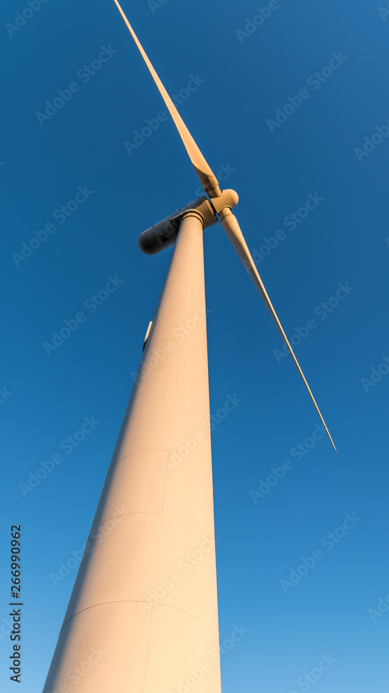 The rotating blades of a windmill against blue sky The rotating blades of a windmill against blue sky