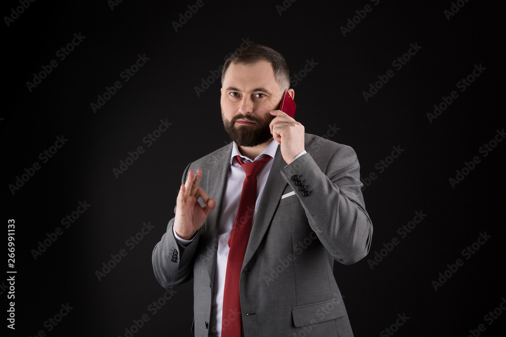 Naklejka premium Guy call friend stand black background. Mobile call concept. Man formal suit call someone. Mobile call conversation. Mobile negotiations. Businessman well groomed mature man hold smartphone.