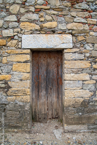 Close-up of the old wooden door of an ancient stone building ruined by time, Sestri Levante, Liguria, Italy
