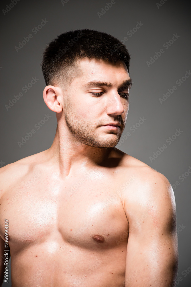 Lifestyle closeup portrait of attractive handsome shirtless young man posing in photo studio