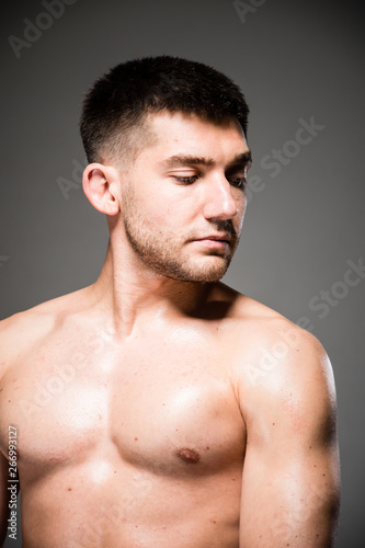 Lifestyle closeup portrait of attractive handsome shirtless young man posing in photo studio