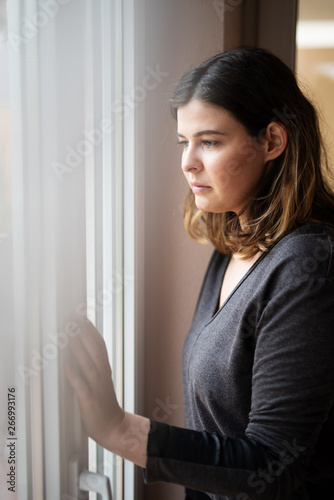 Free Download Frau steht sehnsüchtig am Fenster  - GFXLoad