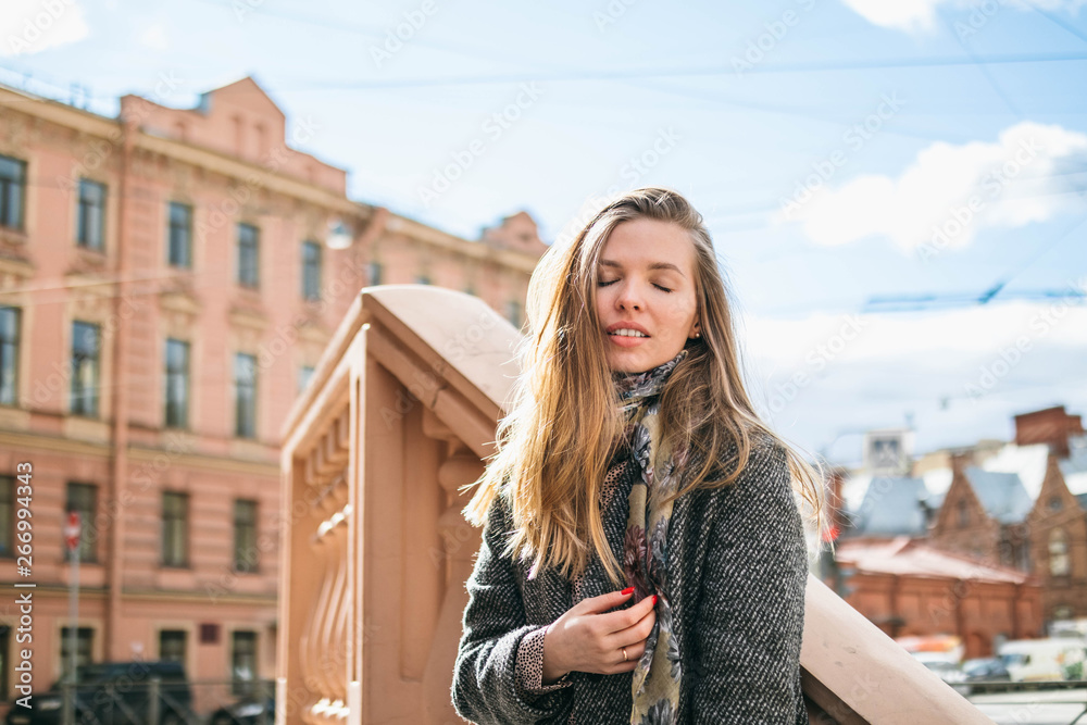 Happy pretty girl in the spring windy city. Self-confidence, power and life goals concept Happy pretty girl in the spring windy city. Self-confidence, power and life goals concept