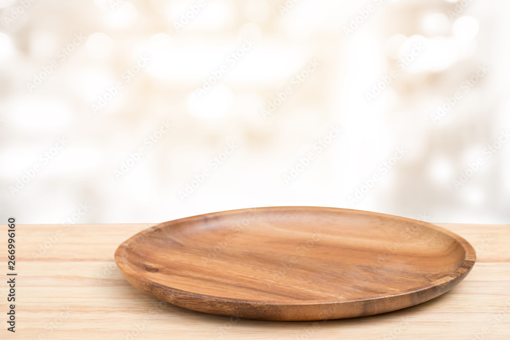 Perspective wooden table and wooden tray on top over blur bokeh light background, can be used mock up for montage products display or design layout