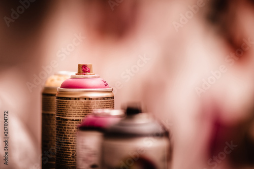 Close up of a pink graffiti art spray against a painted mural background. photo