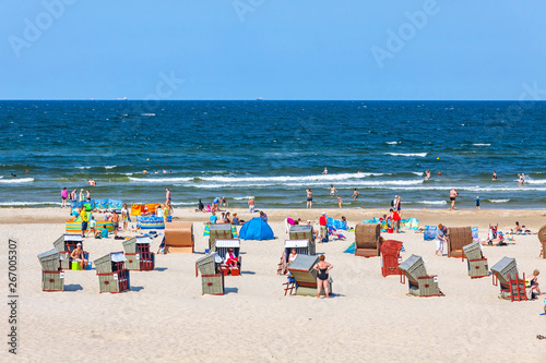 Unrecognisable people relax on a Baltic sea beach on Usedom island in Swinoujscie city, Poland