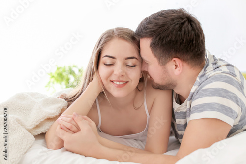 Morning of young lovely couple lying on bed at home