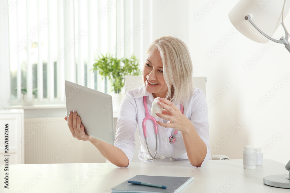 Doctor consulting patient using video chat on tablet in clinic