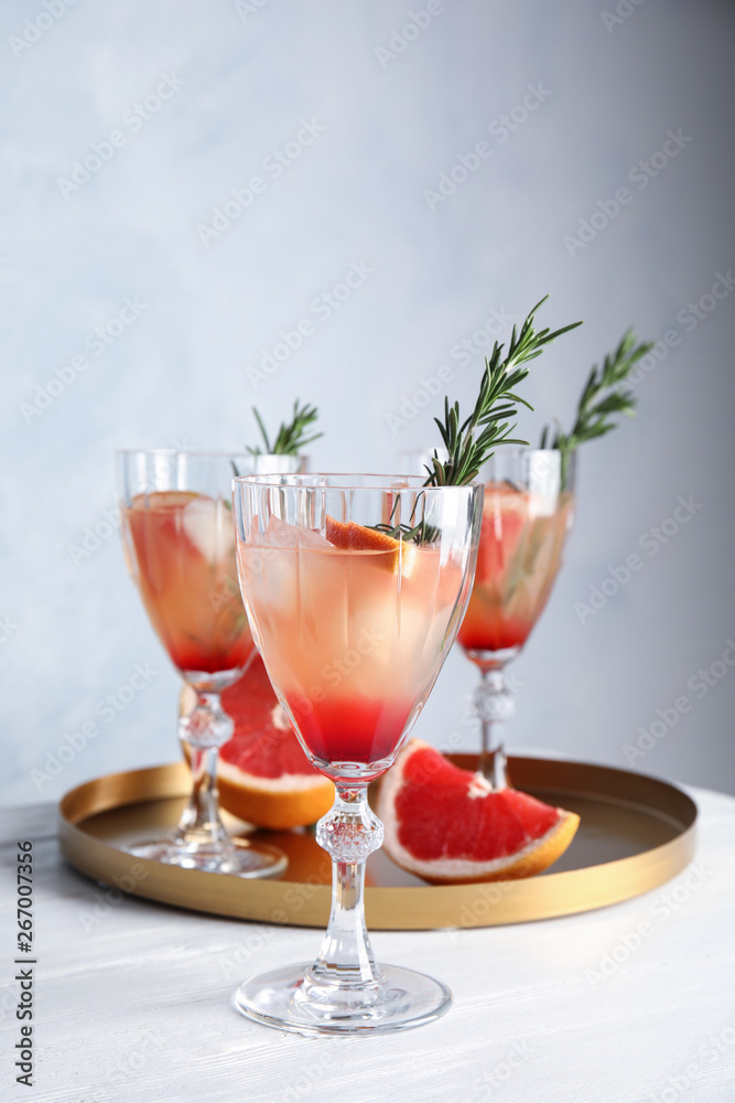 Glasses of grapefruit cocktails on table. Space for text
