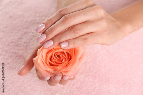 Closeup view of beautiful female hands with rose on towel. Spa treatment