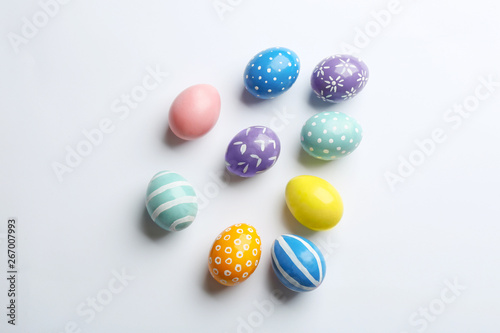 Composition of painted Easter eggs on white background, top view