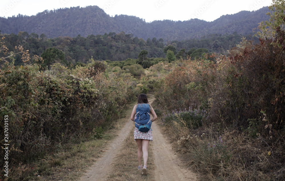 Backpacker adventurer girl hiking over the mountain trails