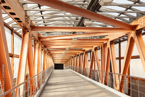 Orange Metal Construction Of Pedestrian Overpass. Pedestrian Bridge Constructed From Heavy Metal Beams And Channels.
