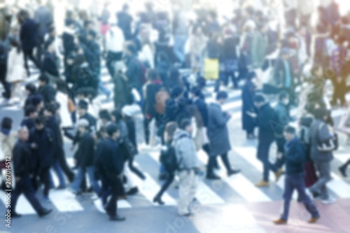 blurred people /crowd are crossing the street in the busy day. The people is mostly the businessmen / salary man in the major big cities. 