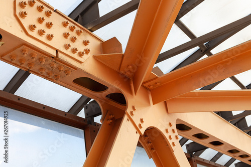 Heavy Beams And Chanals Of Steel Bridge Construction Painted Orange Paint. Metal Framework Of Structure Closeup.