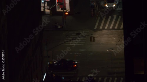 NEW YORK, USA, DECEMBER 2018: CLOSE UP: Pedestrians walk along a busy main road at night-time in New York. Yellow taxis, cars and buses drive through the dark alleys of a metropolitan city in America.