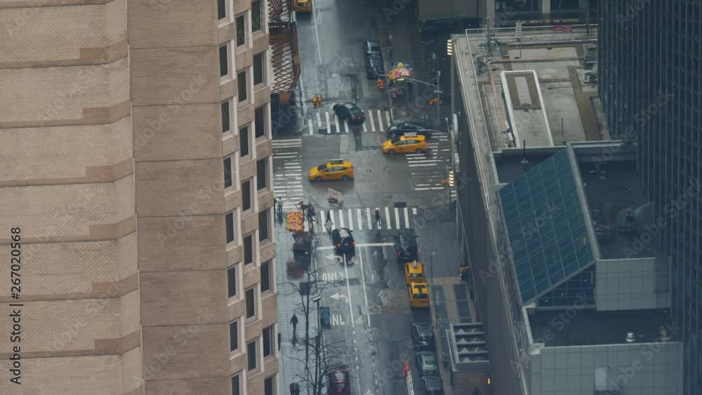 TIMELAPSE, CLOSE UP: Cool shot of a busy road junction on a rainy day in New York. Cars drive down the wet road and past pedestrians on the sidewalks in New York. People cross a busy road in Manhattan TIMELAPSE, CLOSE UP: Cool shot of a busy road junction on a rainy day in New York. Cars drive down the wet road and past pedestrians on the sidewalks in New York. People cross a busy road in Manhattan