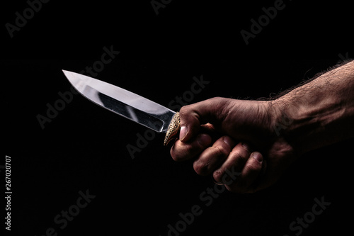 фотографія Hunting knife in hand on dark background