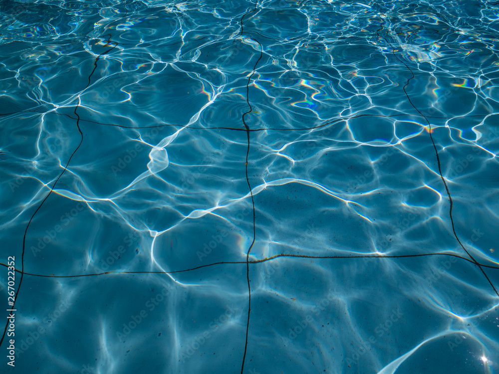Dirty pool filled with water. The sun creates glare on the surface of the water Dirty pool filled with water. The sun creates glare on the surface of the water